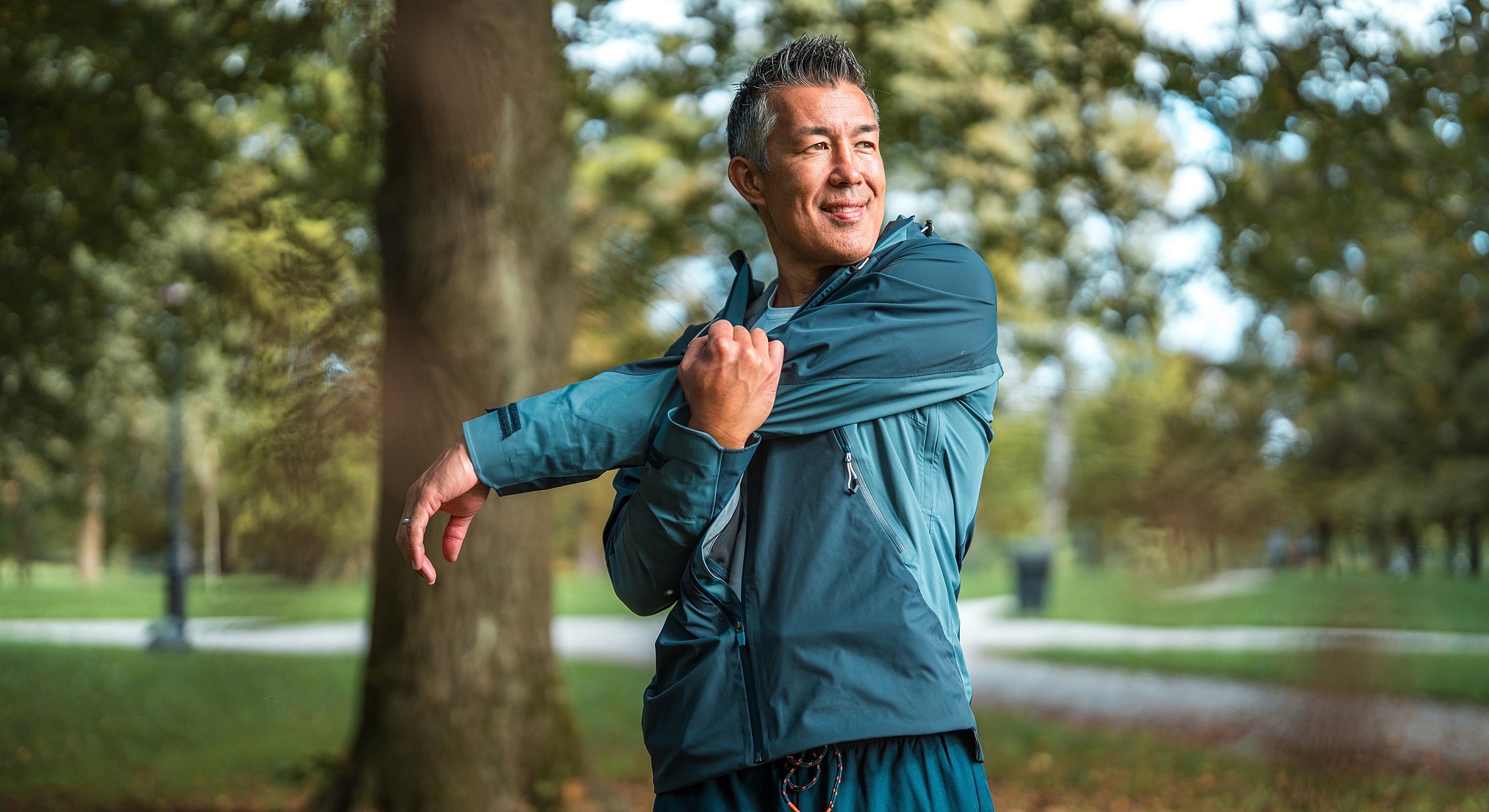 Man stretching in athletic wear outdoors.